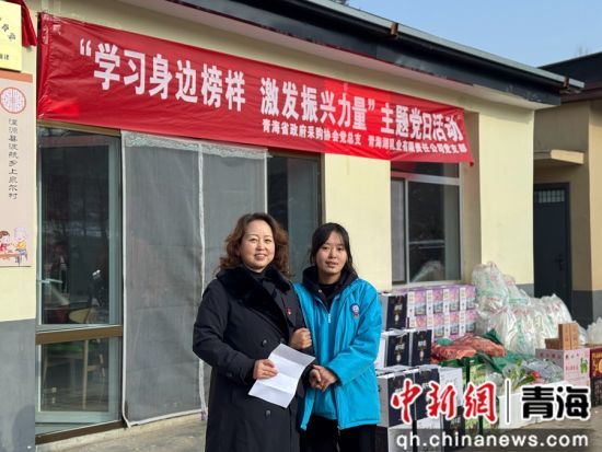 图为物资捐赠现场，村民代表向协会发表感谢信后合影。 何惠姗 摄