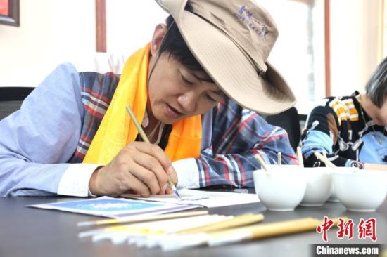 图为香港媒体代表体验唐卡绘制。张海雯摄 图为香港媒体代表体验唐卡绘制。张海雯摄