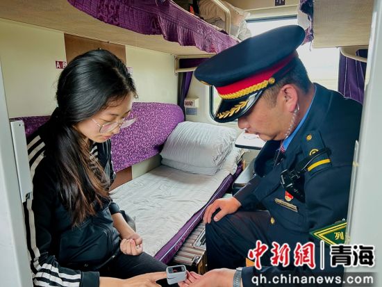 图为列车长为志愿服务西部计划的青年志愿者测量血氧。 阿忠仁摄