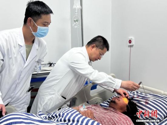 资料图为朱鑫璞(中)在玛沁县人民医院为患者诊疗。受访者供图