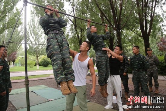 图为余乐斌教练团队成员正在给官兵进行单杠教学与纠错。 刘进峰摄 图为余乐斌教练团队成员正在给官兵进行单杠教学与纠错。 刘进峰摄