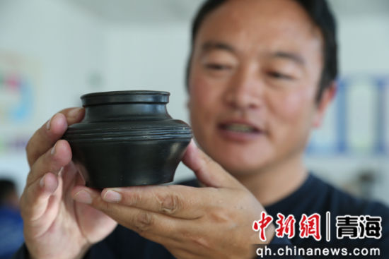 图为果洛谢格太展示黑陶作品。张忠苹摄 图为果洛谢格太展示黑陶作品。张忠苹摄