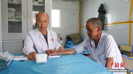 图为安置点内医护人员为村民测量血压。 祁妙摄 图为安置点内医护人员为村民测量血压。 祁妙摄