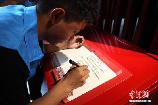 图为青海玉树藏族学子在留言簿上用藏语写下美好祝愿。张海雯 摄