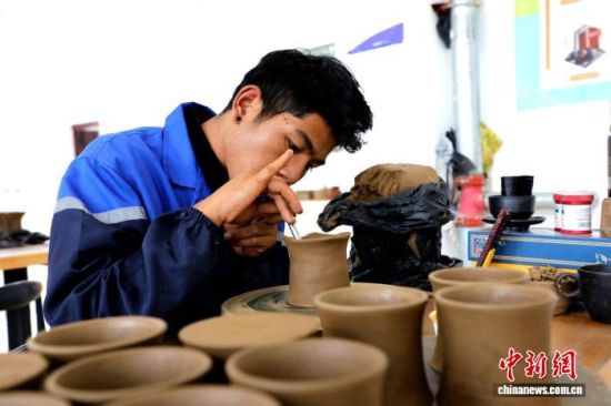 图为在班玛县电子商务公共服务中心黑陶体验馆中,艺人正在制作黑陶器具。马铭言 摄 图为在班玛县电子商务公共服务中心黑陶体验馆中,艺人正在制作黑陶器具。马铭言 摄